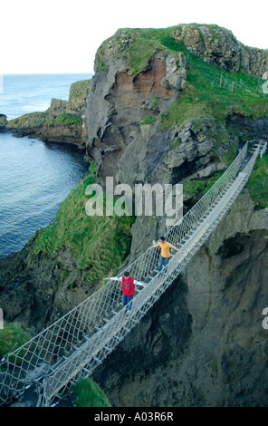 zwei jungen, die zu Fuß über Carrick ein Rede Rope Bridge an der Causeway-Küste in der Grafschaft Antrim in Nordirland Stockfoto