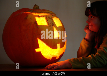 Mädchen Blick stolz auf ihre großen Kürbis hat sie für Halloween vorbereitet. Stockfoto