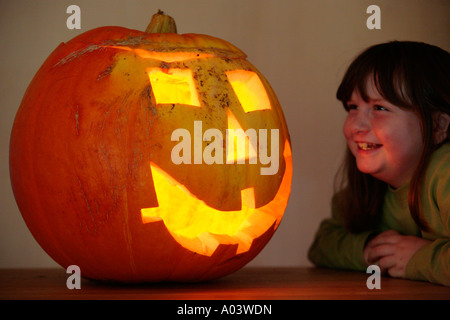 Mädchen Blick stolz auf ihre großen Kürbis hat sie für Halloween vorbereitet. Stockfoto