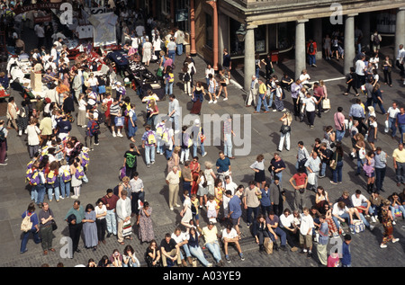 Covent Garden Luftaufnahme Sommer Blick Menschenmenge von oben Gruppe sitzen Unterhaltung Gruppen Einkaufen an Marktständen London England Großbritannien Stockfoto