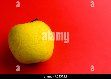 fauler Apfel auf rotem Grund Stockfoto