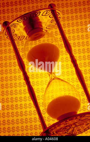 Sanduhr mit Geld Symbole im Hintergrund Stockfoto