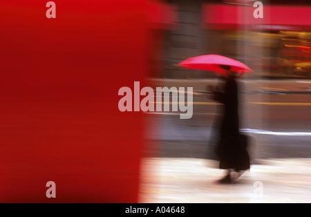 Frau mit roten Regenschirm verschwommen aussehen U S A New York City Stockfoto