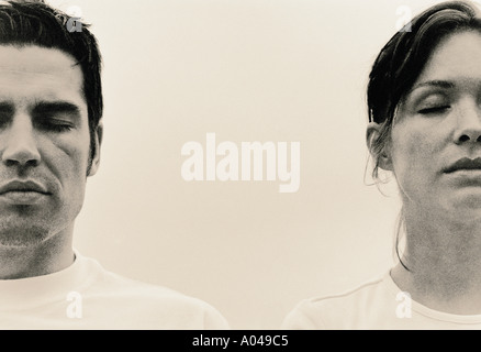 Porträt von Mann und Frau stehen Seite an Seite mit geschlossenen Augen Stockfoto