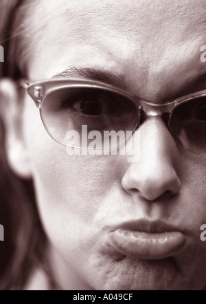 Porträt einer jungen Frau mit Brille schmollend ihre Lippen Stockfoto