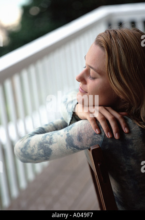 Junge Frau sitzt auf einem Stuhl entspannen Stockfoto