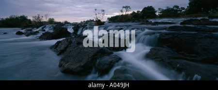 Afrika-Namibia-The Okavango-Fluss fließt über Popa Fälle in der Abenddämmerung im Caprivi-Streifen Stockfoto