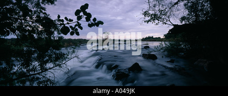 Afrika-Namibia-The Okavango-Fluss fließt über Popa Fälle in der Abenddämmerung im Caprivi-Streifen Stockfoto