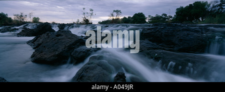 Afrika-Namibia-The Okavango-Fluss fließt über Popa Fälle in der Abenddämmerung im Caprivi-Streifen Stockfoto