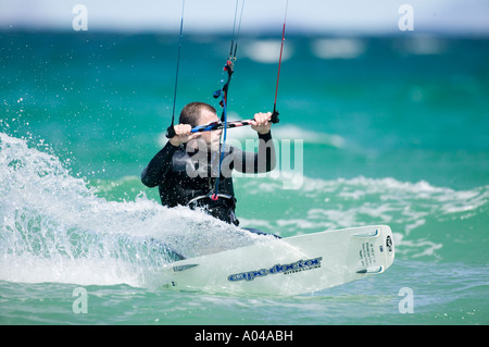 Südafrika Western Cape Provinz Kapstadt Herr Kitesurfer reitet durch brechende Wellen in Fish Hoek Beach Stockfoto