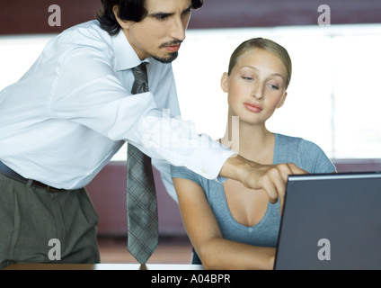 Unternehmer helfen Geschäftsfrau mit laptop Stockfoto