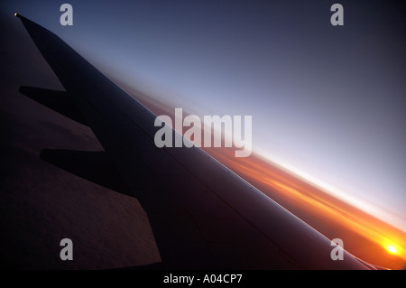 Flugzeug fliegen in Richtung Sonnenaufgang Stockfoto