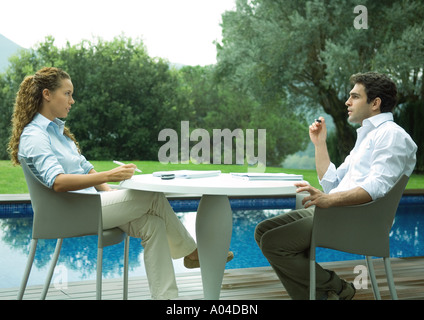 Lässig gekleidet junge Führungskräfte arbeiten in der Nähe von Rand des Pools Stockfoto