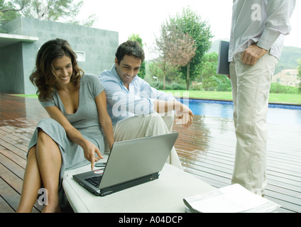 Lässig gekleidet junge Führungskräfte arbeiten in der Nähe von Rand des Pools Stockfoto