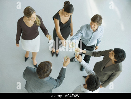 Junge Führungskräfte, die Erhöhung der Gläser für Toast, erhöhte Ansicht Stockfoto