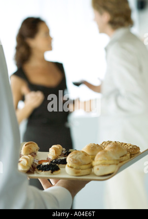 Server mit Tablett mit Häppchen während cocktail-party Stockfoto