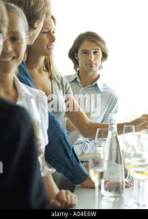 Gruppe junger Erwachsener in bar Mann im Hintergrund Blick in die Kamera im Mittelpunkt stehen Stockfoto