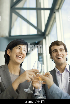 Junge Führungskräfte klirrende Gläser Champagner und lachen Stockfoto