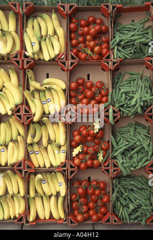 Gemüsegeschäft präsentiert farbenfrohe Auslage mit Obst und Gemüse in Kisten, darunter Bananen, Tomaten und Hülsenfrüchte, gesehen in einem Laden in Essex, England, UK Stockfoto