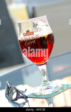 Bellevue Kriek belgisches Bier auf einem Glastisch mit ein paar Sonnenbrillen, Hasselt, Belgien Stockfoto