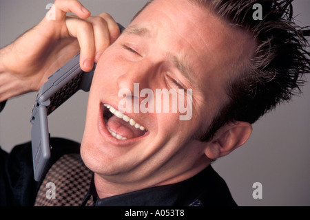 Porträt des expressiven Komiker ein Telefon Gespräch über lustige Sachen sprechen und erzählt einen Witz Stockfoto