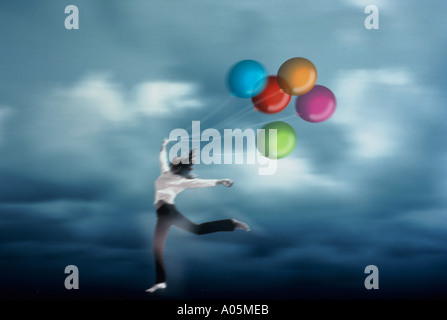 Frau mit Multi farbige Luftballons, wie sie mit Glück springt Stockfoto