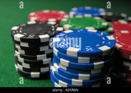 Stapel von farbigen Pokerchips auf grünem Filz Stockfoto