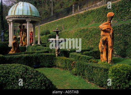 Holz-Skulpturen-Brunnen und ein kleiner Tempel in Scherrer Park Morcote Schweiz Stockfoto