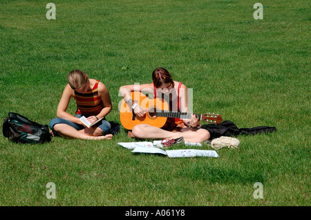 Junge Mädchen, die Gitarre zu spielen, in einem öffentlichen Park in der Kampa-Insel, kleinen Viertel Prag Tschechische Republik Stockfoto