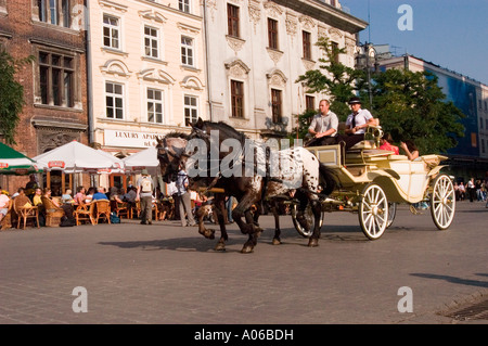 Traditionelle touristische Pferdekabinen auf dem Hauptplatz Krakau oder Krakau Polen. Sightseeing-Kutsche mit Pferden in der historischen Altstadt. Stockfoto
