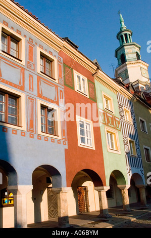 Reihe von kleinen bunten Häusern mit Bogengängen auf dem Alten Marktplatz Posen Polen, mit dekorativen Fassaden und einem Uhrenturm Hintergrund. Stockfoto