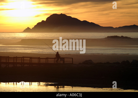 Fischer zu Fuß am Strand bei Sonnenuntergang Stockfoto