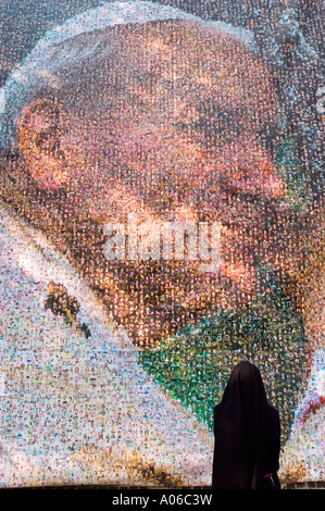 Katholische Nonne in schwarzer Angewohnheit, die ein massives Foto-Mosaik von Papst Johannes Paul II. Aus Bildern von Gläubigen in Polen sieht. Stockfoto