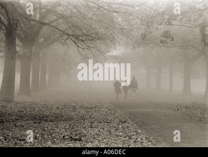 Familie läuft die Parkallee entlang im Nebel, Hyde Park, London Stockfoto