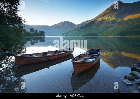 Boote am Ufer Buttermere im Morgengrauen Cumbria Lakes Distrikt Cumbria England UK Stockfoto