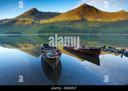 Boote am Ufer Buttermere im Morgengrauen Cumbria Lakes Distrikt Cumbria England UK Stockfoto