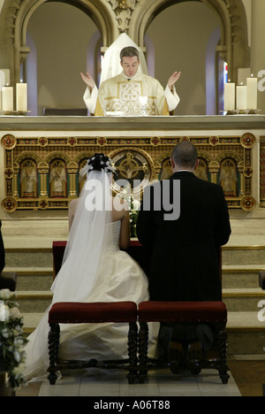 Braut und Bräutigam die Gebete während Großbritannien katholische Trauung Stockfoto