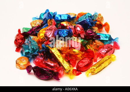 Saisonale festliche bunte Pralinen Süßigkeiten Bonbons mit glänzenden Folie Wrapper in einem Stapel auf weißem Hintergrund Stockfoto