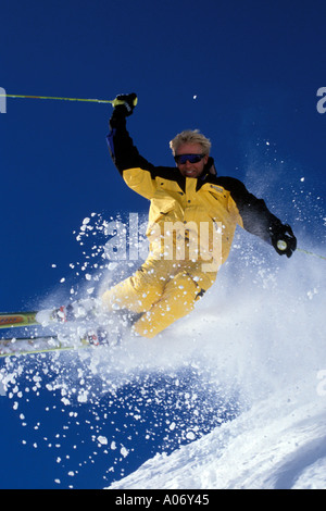 Gewagte männlichen Skifahrer auf den Pisten im gelben Skianzug Stockfoto