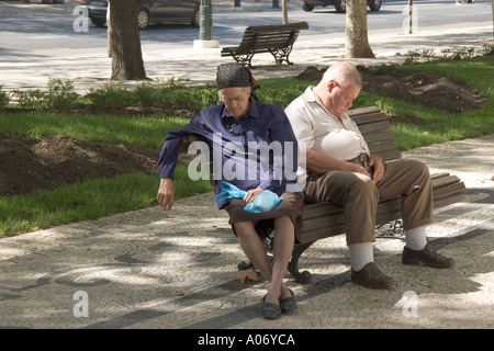 Lissabon Portugal alte paar Übernahme Siesta auf Parkbank in Avenida da Liberdade Stockfoto