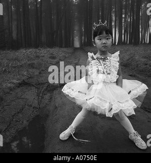 Porträt junge kleine Prinzessin Multi Asian Japanerin in Ballerina Ballett Tutu und Tiara zuversichtlich Gesicht Augen im Wald Wald Stockfoto