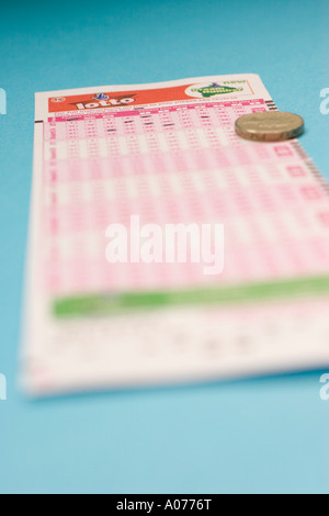 UK Lotto-National Lottery spielen Slip Anmeldeformular mit Pfund-Münze Stockfoto
