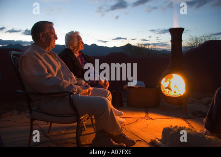 Älteres Ehepaar entspannen am Kamin Stockfoto