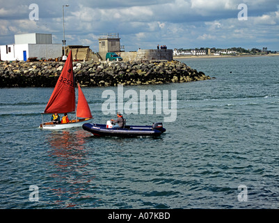 DUN LAOGHAIRE Republik von Irland Europa Juni lernen eine Jolle Segeln im Hafen Escort steht für jedes problem Stockfoto