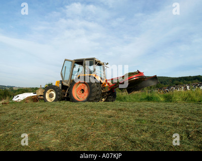 Herstellung von Silage verdichten das Gras Heu mit einem Traktor in einem Feld silo Stockfoto