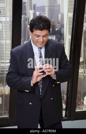 CEO SMS auf Handy in seiner Hütte im Business-Anzug zu sehen Stockfoto