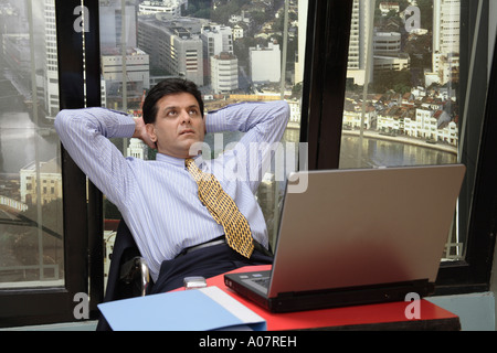 CEO denken arbeiten am Laptop in seiner Kabine mit Stadt-Hintergrund Stockfoto