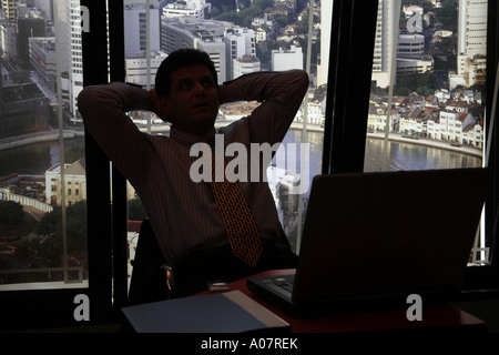 CEO denken arbeiten am Laptop in seiner Kabine mit Stadt-Hintergrund Stockfoto