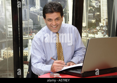CEO arbeiten am Laptop in seiner Kabine mit Stadt-Hintergrund Stockfoto