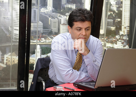 CEO arbeiten auf Laptop-Computer in seiner Kabine mit Stadt-Hintergrund Stockfoto
